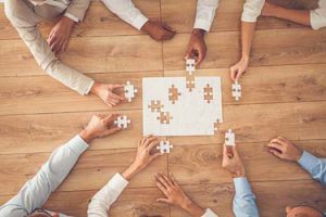 people assembling puzzle